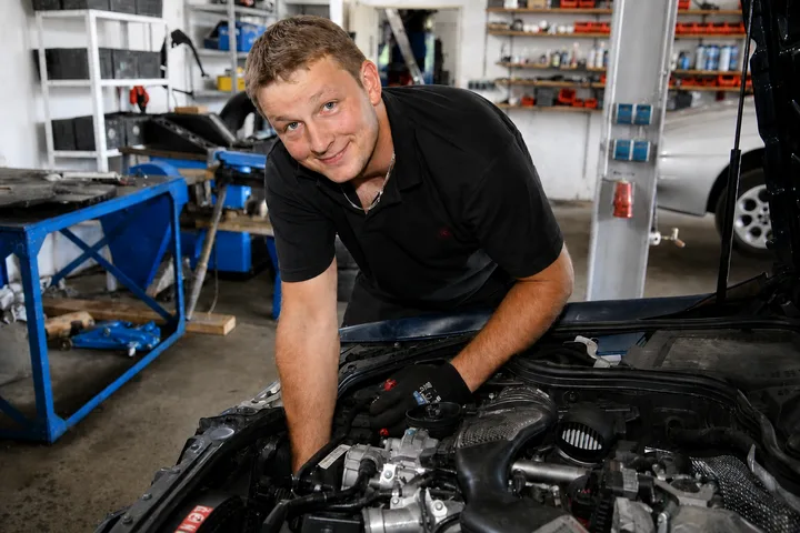 Mechaniker der KFZ Werkstatt Niedermeier repariert einen Motor in der Werkstatt in Scheyern